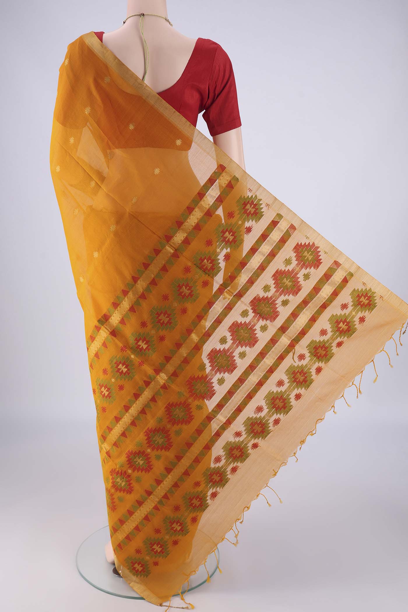 Flat view of Mustard Silk Cotton Saree with Zari Butta on the body and Zari Border. 