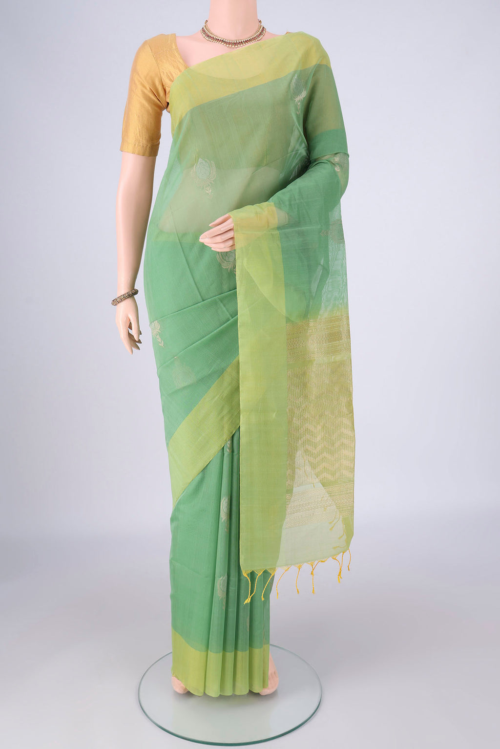 Light Green Silk Cotton Saree with Zari Butta on the body and Plain Border.  displayed on a mannequin