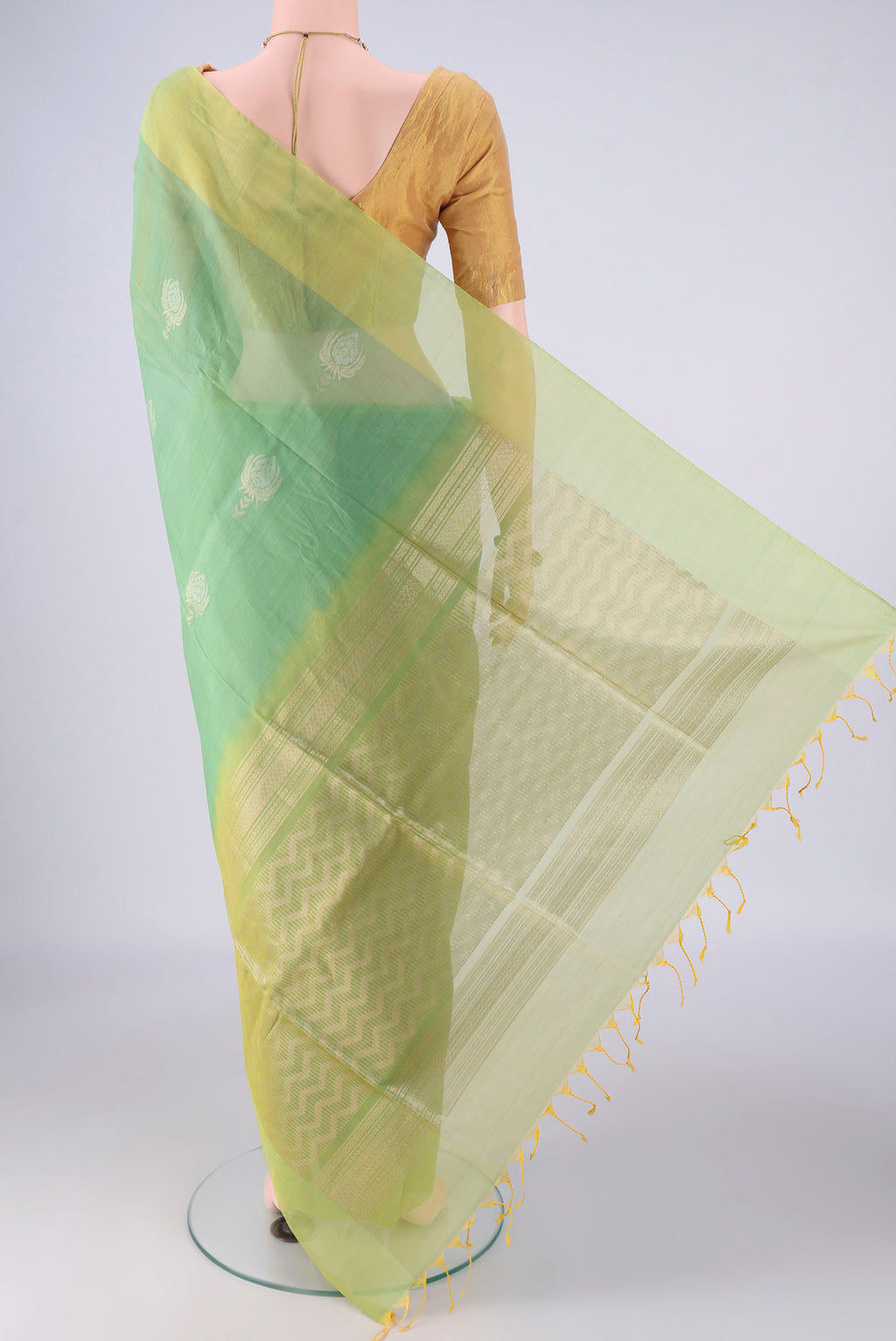 Flat view of Light Green Silk Cotton Saree with Zari Butta on the body and Plain Border. 