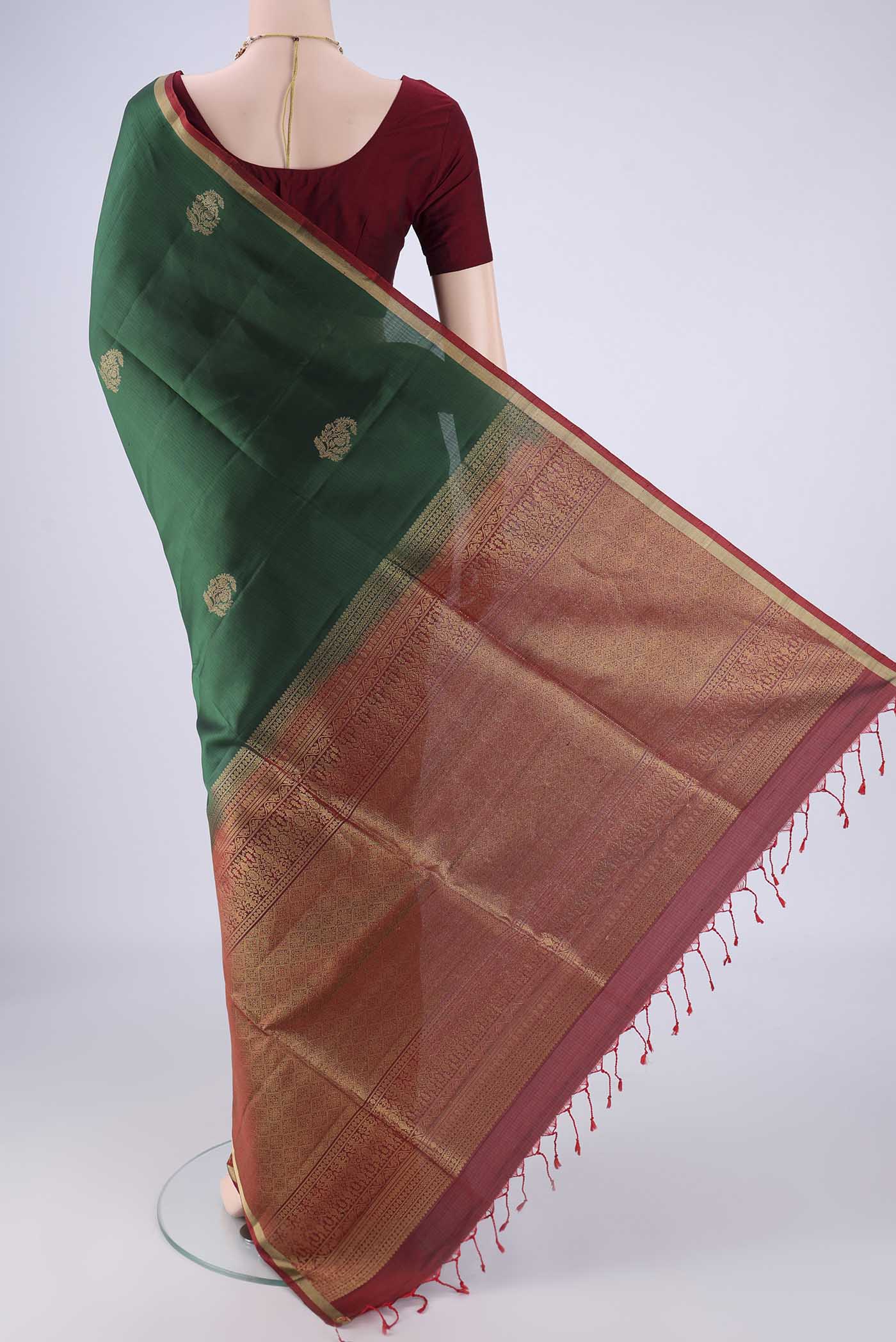 Flat view of Bottle Green Soft Silk Saree with Zari Butta on the body and Zari Border. 