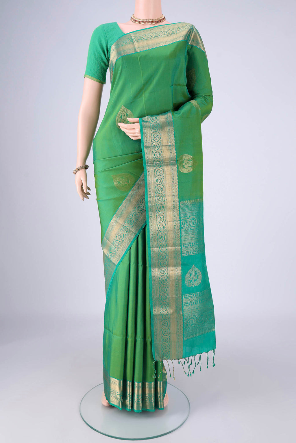Light Green Soft Silk Saree with Zari Butta on the body and Zari Border.  displayed on a mannequin
