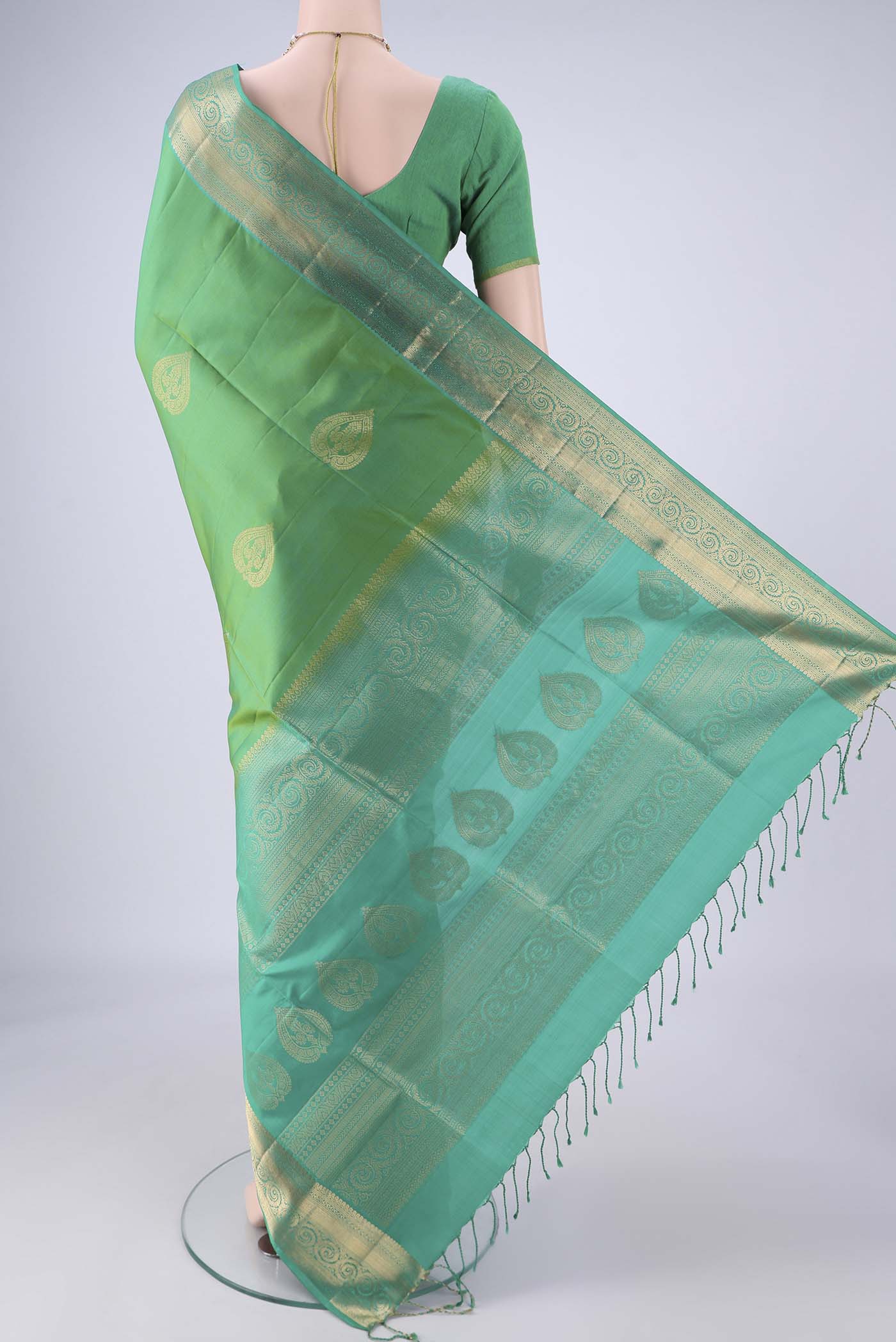 Flat view of Light Green Soft Silk Saree with Zari Butta on the body and Zari Border. 
