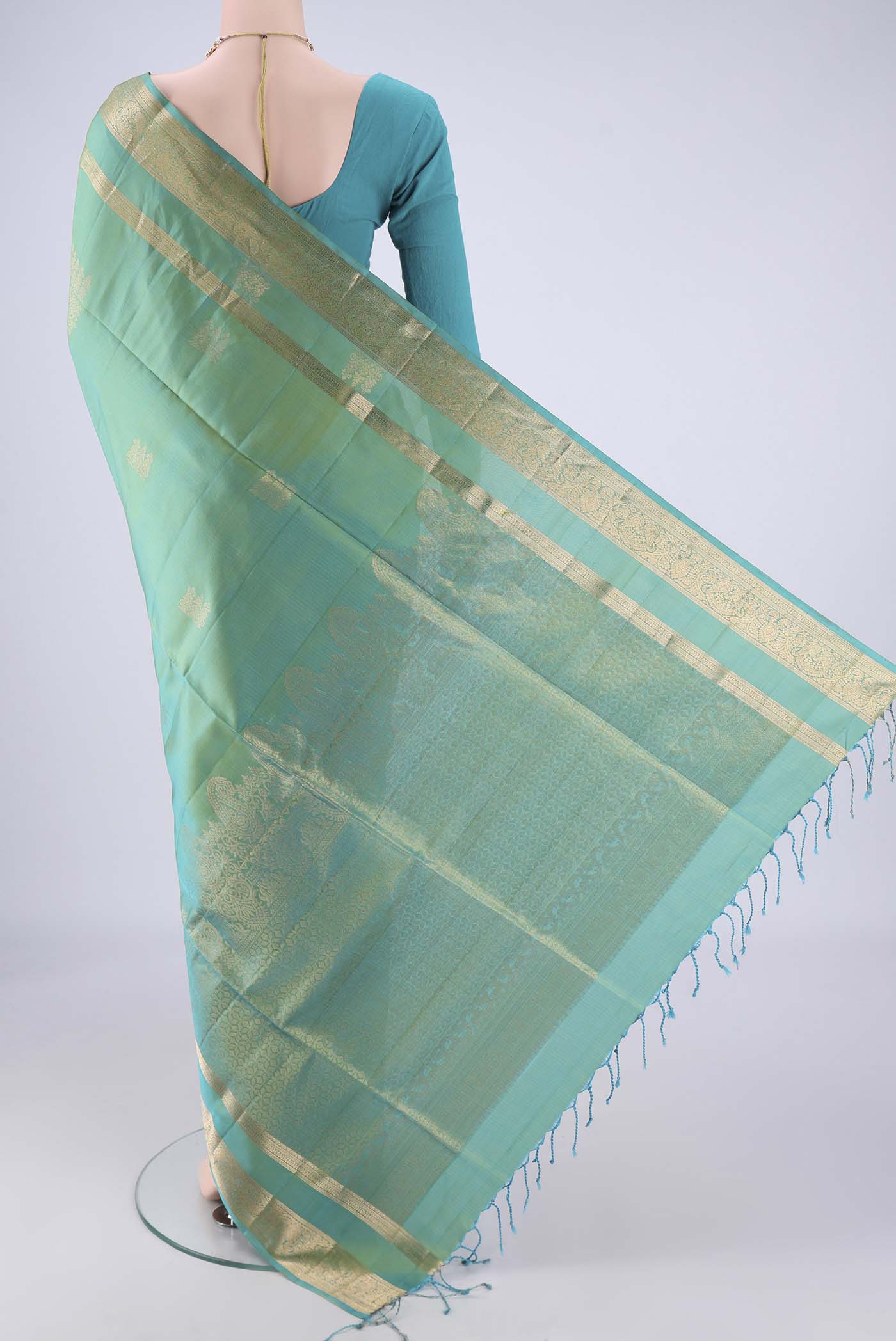 Flat view of Sea Green Dual Tone Soft Silk Saree with Zari Butta on the body and Zari Border. 