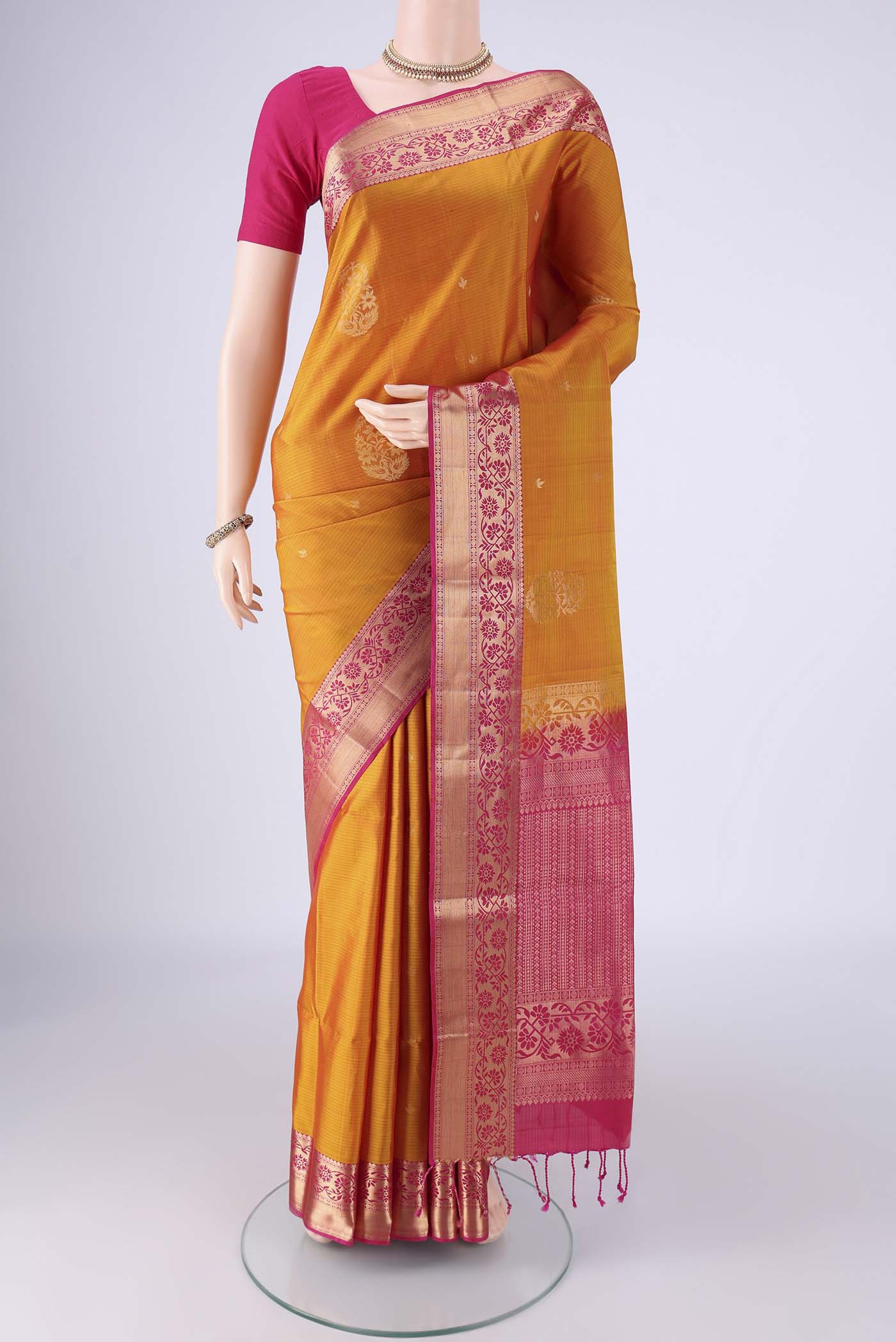 Mustard Soft Silk Saree with Zari Butta on the body and Zari Border.  displayed on a mannequin