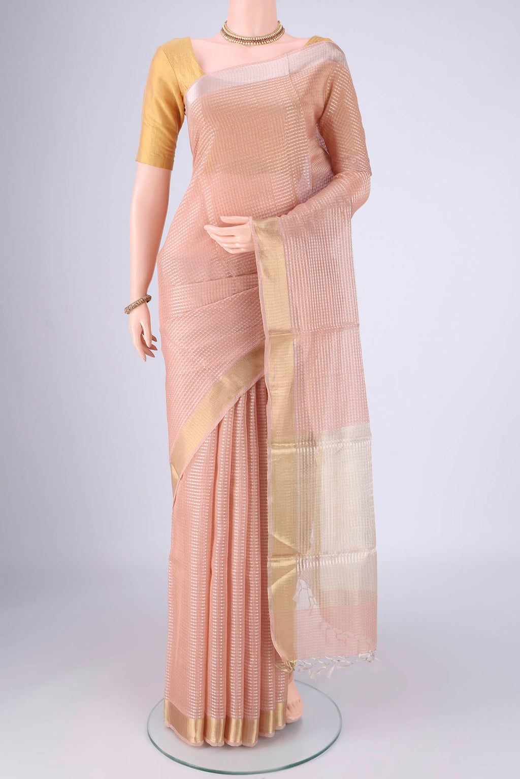 Peach Tussar Silk Saree with Checked design on the body and Zari Border.  displayed on a mannequin