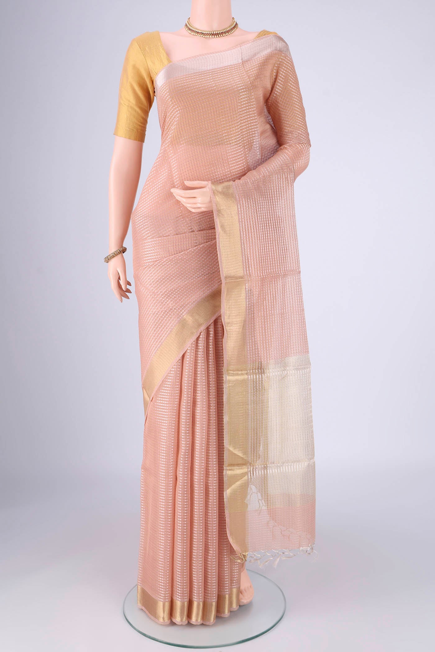 Peach Tussar Silk Saree with Checked design on the body and Zari Border.  displayed on a mannequin