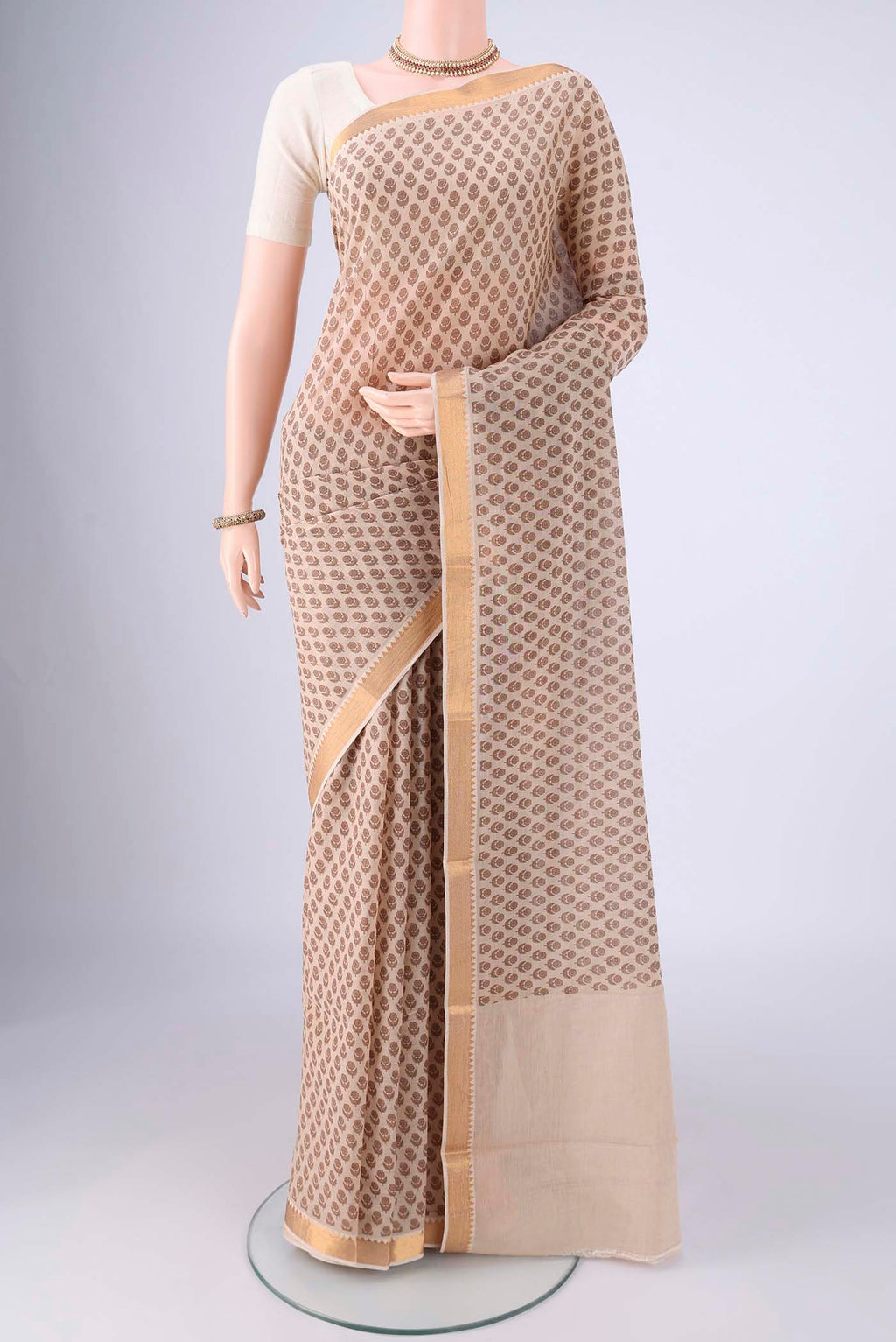 Beige Mangalagiri Cotton Saree with Printed design on the body and Zari Border.  displayed on a mannequin