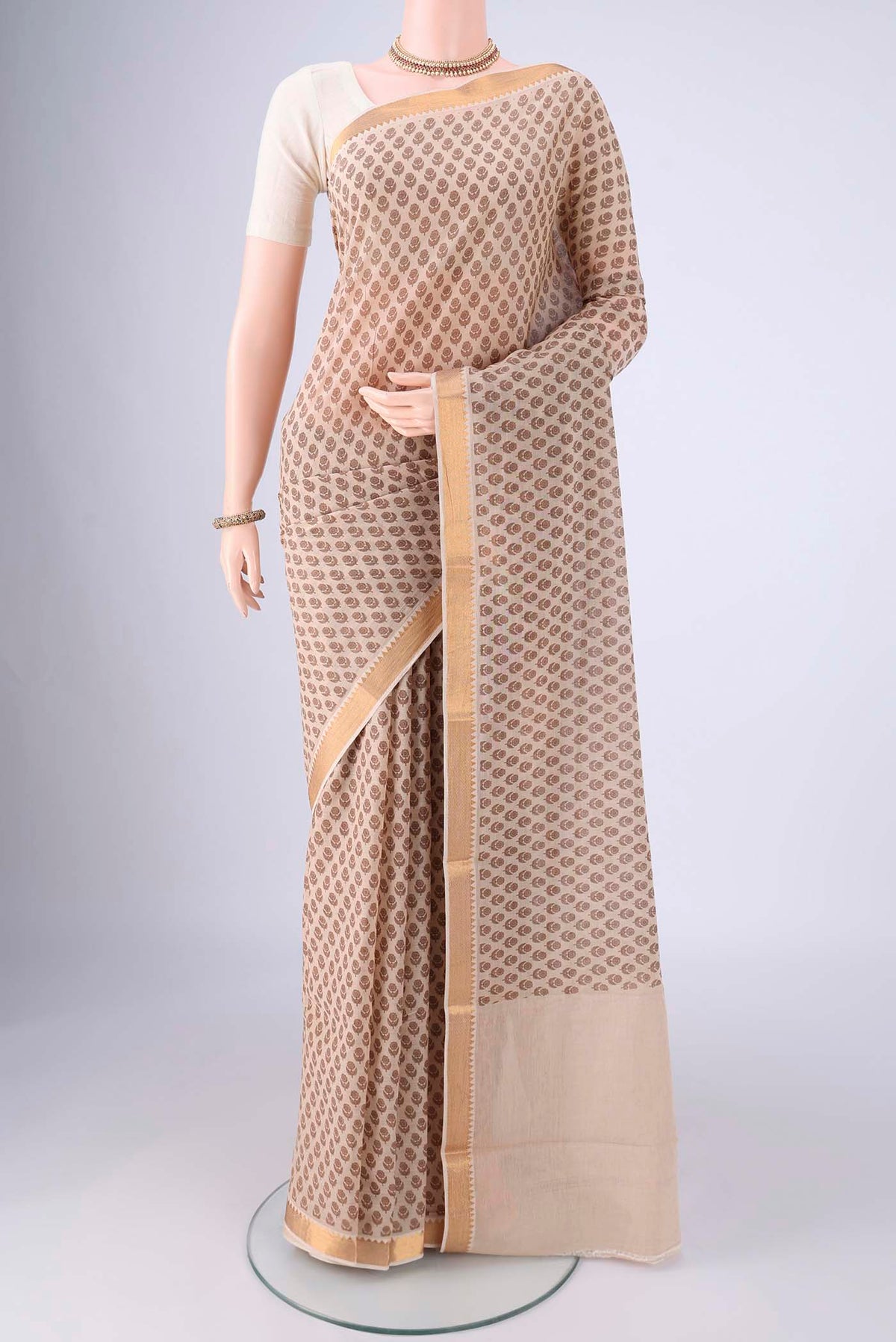 Beige Mangalagiri Cotton Saree with Printed design on the body and Zari Border.  displayed on a mannequin