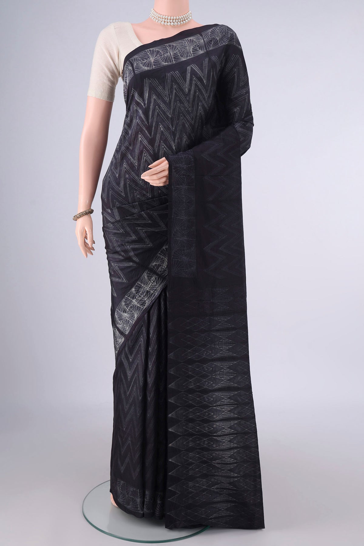Pure Silk Black Printed Saree with Printed design on the body and Printed Border.  displayed on a mannequin