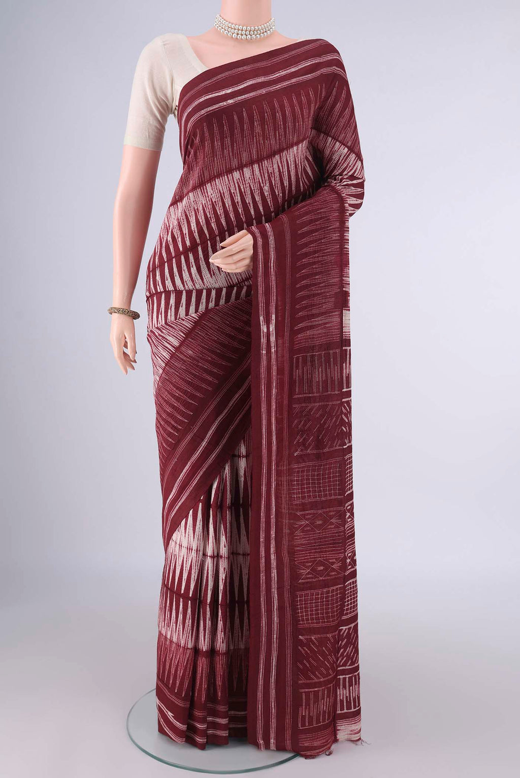 Rust Tussar Saree with Geometric Print on the body and Printed Border.  displayed on a mannequin