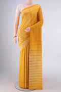 Yellow Tussar Saree with Printed design on the body and Printed Border.  displayed on a mannequin