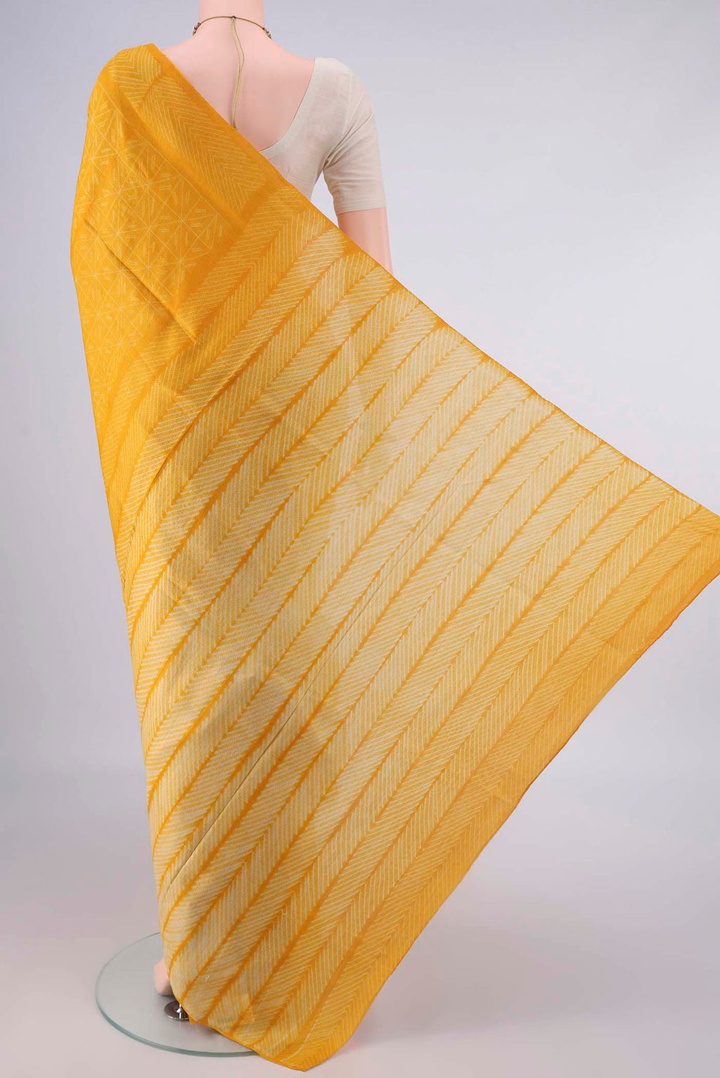 Flat view of Yellow Tussar Saree with Printed design on the body and Printed Border. 