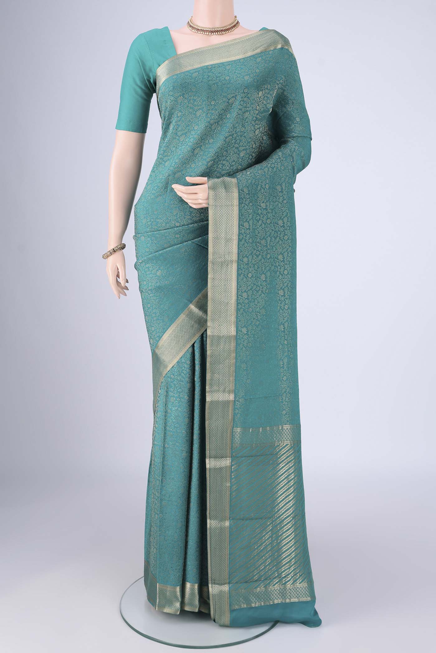 Sea Green Mysore Crepe Saree with Zari Brocade on the body and Zari Border.  displayed on a mannequin