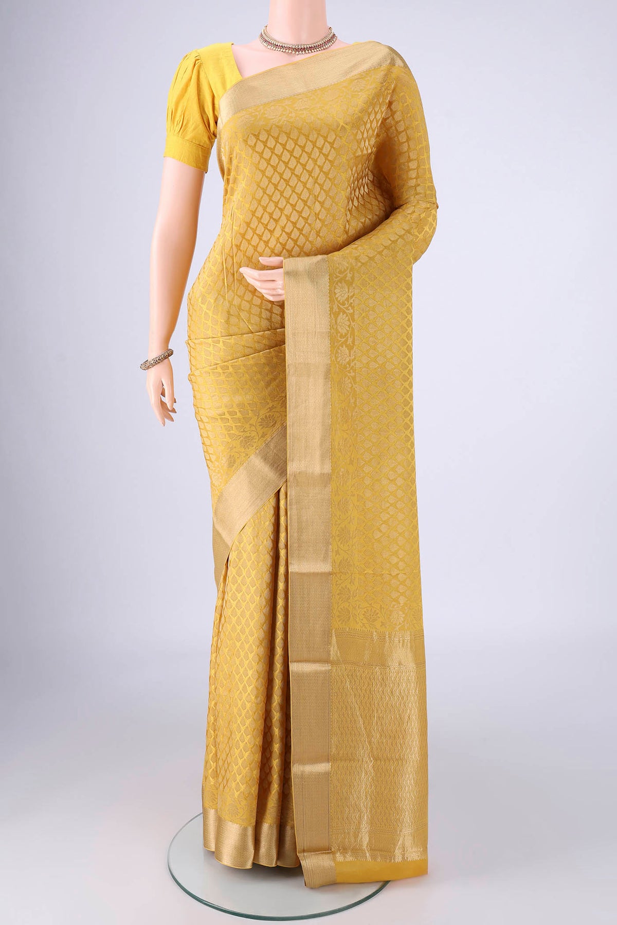 Yellow Mysore Crepe Saree with Zari Brocade on the body and Zari Border.  displayed on a mannequin