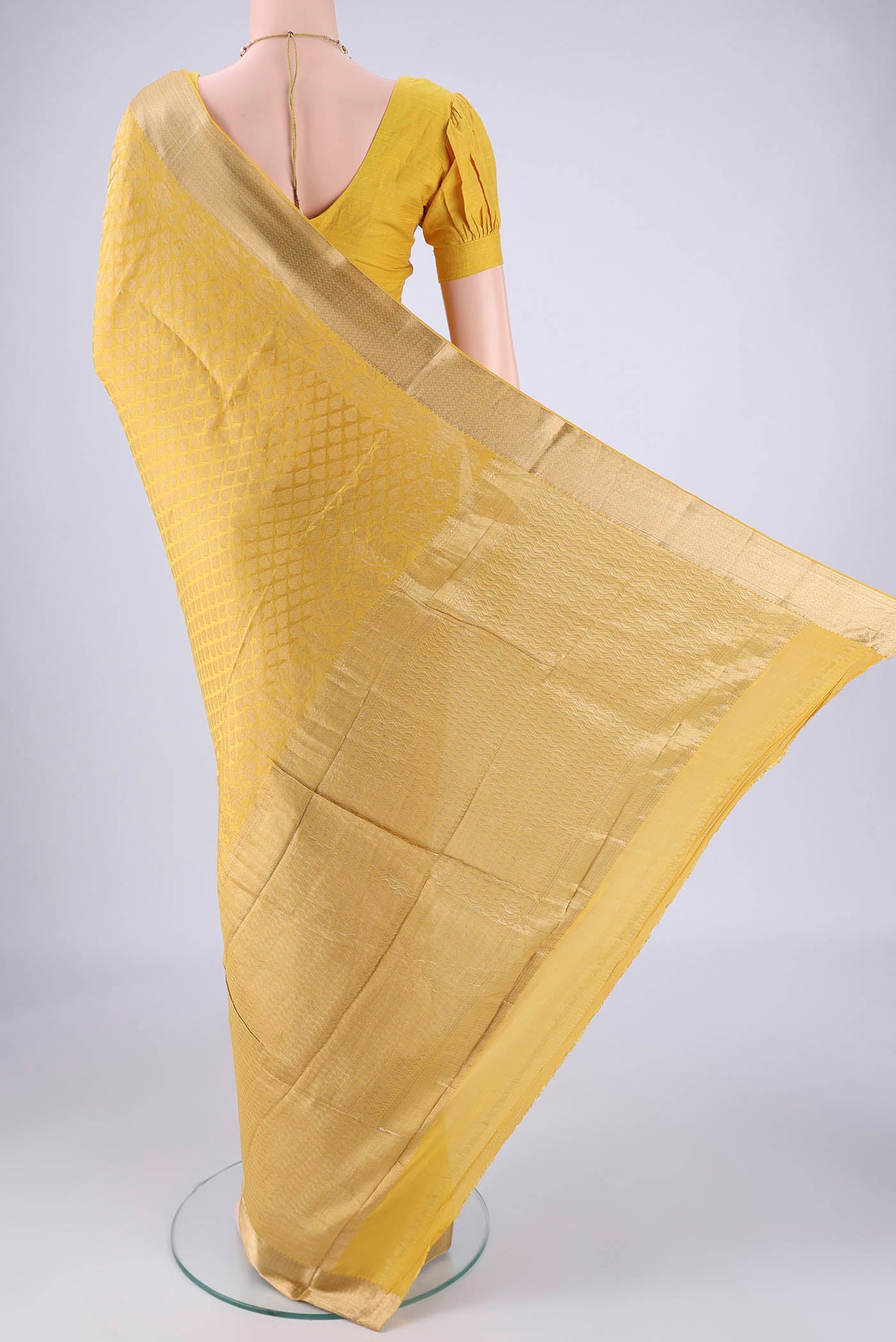 Flat view of Yellow Mysore Crepe Saree with Zari Brocade on the body and Zari Border. 
