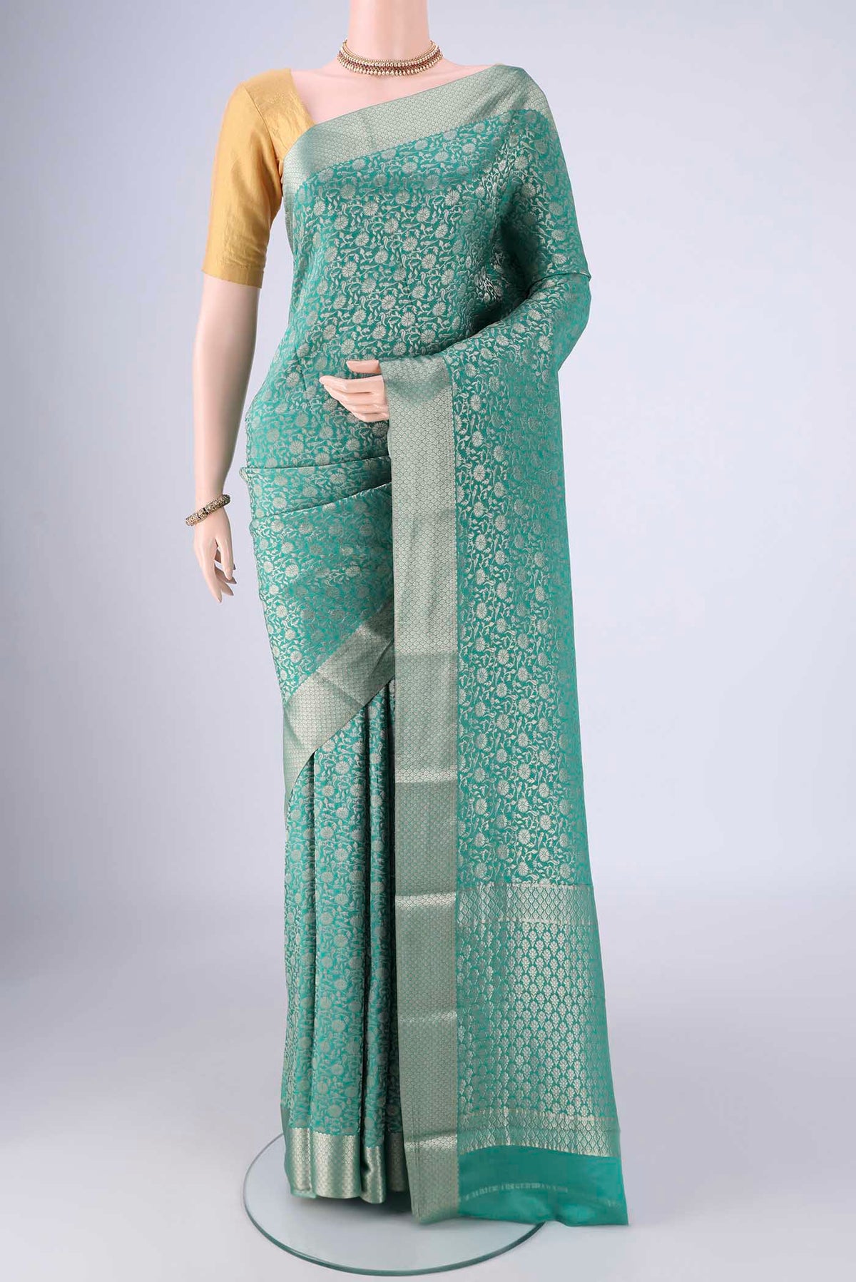 Sea Green Mysore Crepe Saree with Zari Brocade on the body and Zari Border.  displayed on a mannequin
