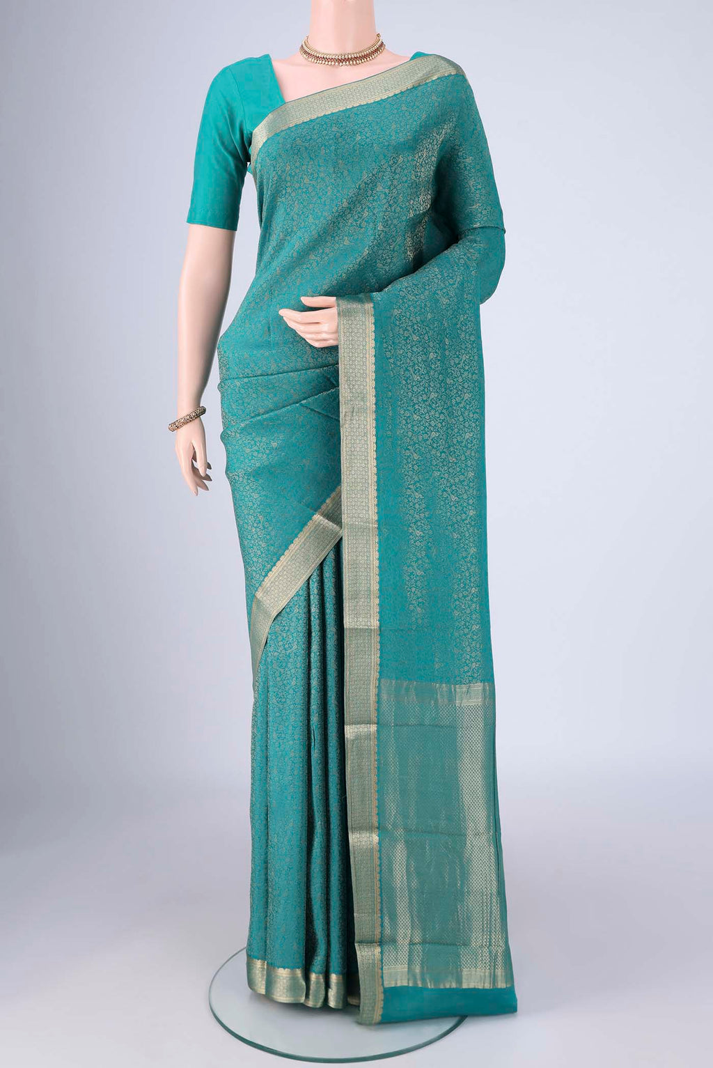 Sea Green Mysore Crepe Saree with Zari Brocade on the body and Zari Border.  displayed on a mannequin