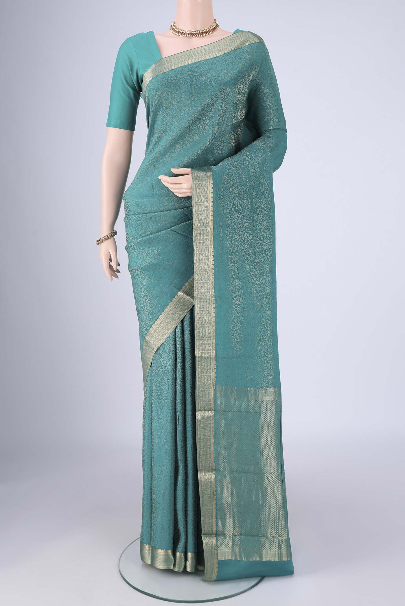 Sea Green Mysore Crepe Saree with Zari Brocade on the body and Zari Border.  displayed on a mannequin
