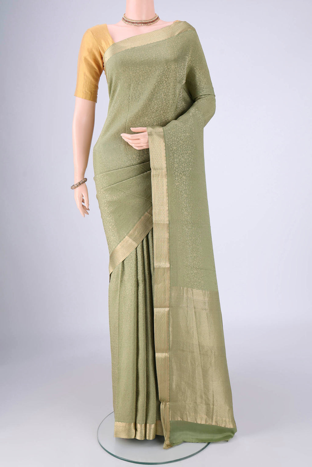 Sage Green Mysore Crepe Saree with Zari Brocade on the body and Zari Border.  displayed on a mannequin