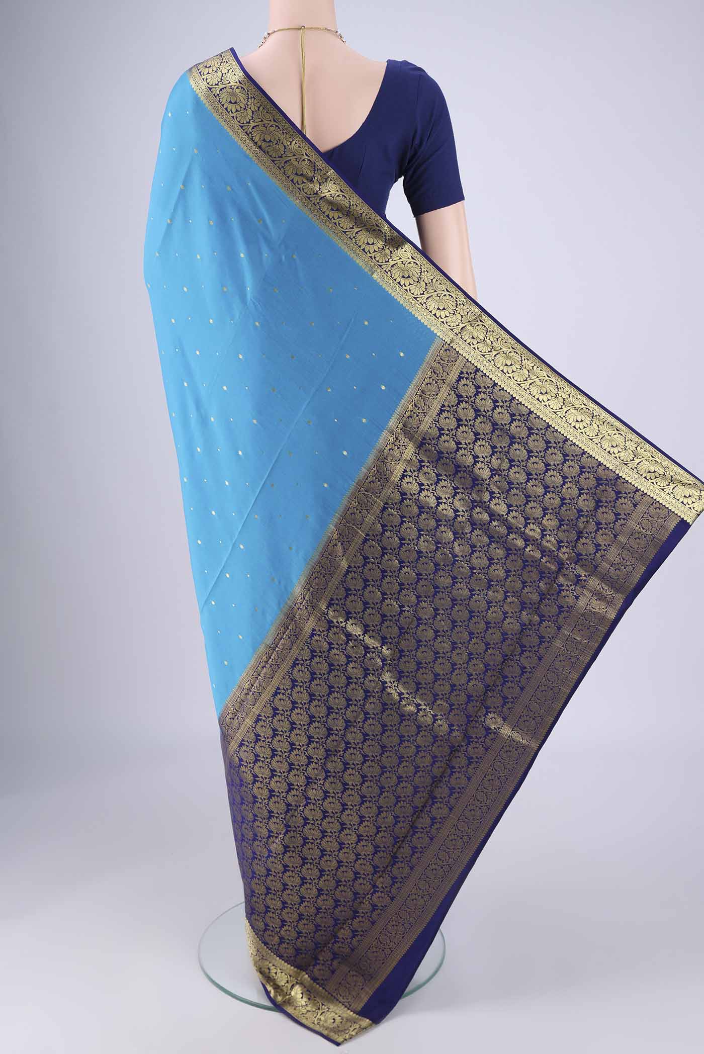 Flat view of Blue Mysore Crepe Saree with Zari Butta on the body and Zari Border. 