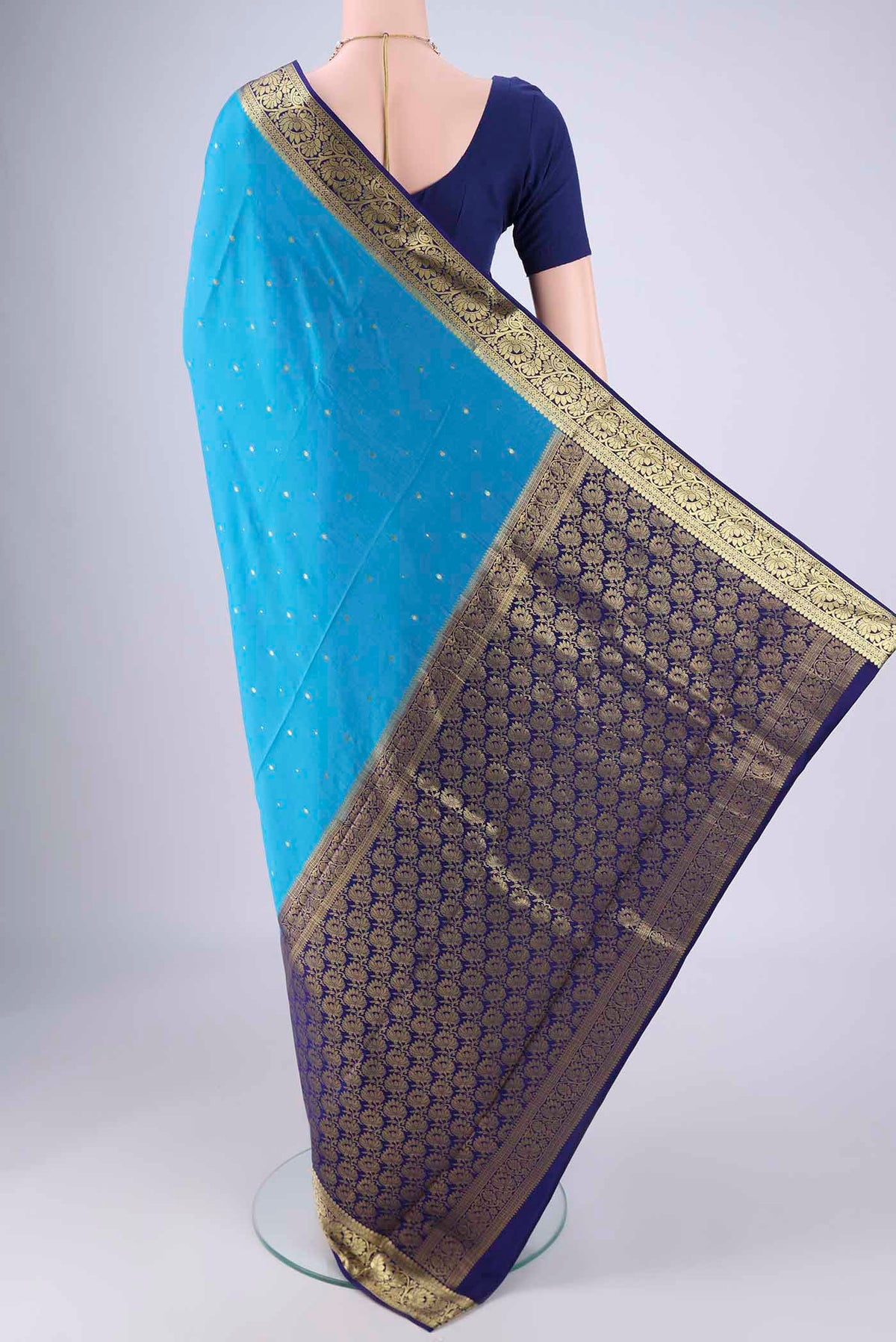 Flat view of Blue Mysore Crepe Saree with Zari Butta on the body and Zari Border. 