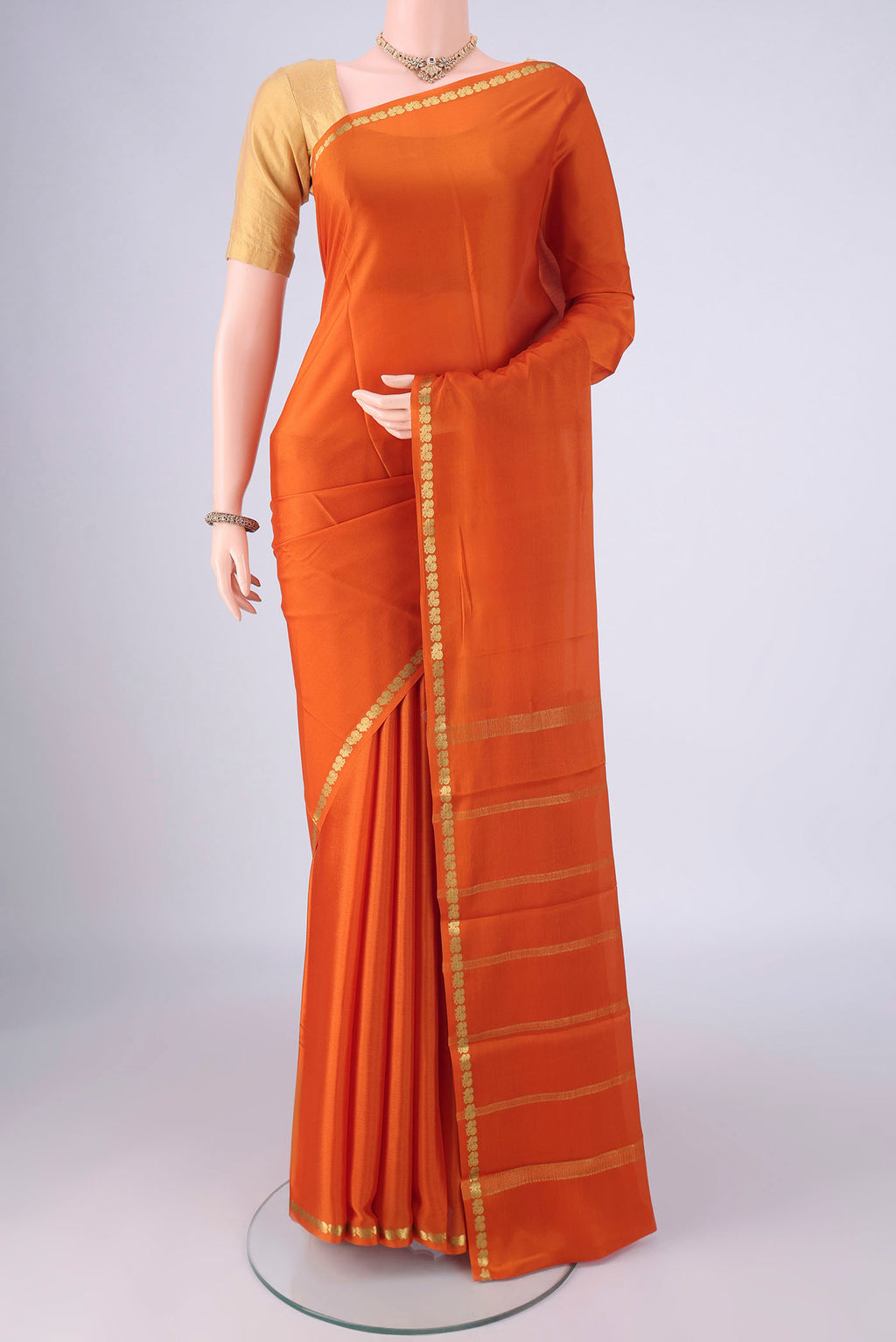 Orange Mysore Crepe Saree with Plain Body and Zari Border.  displayed on a mannequin