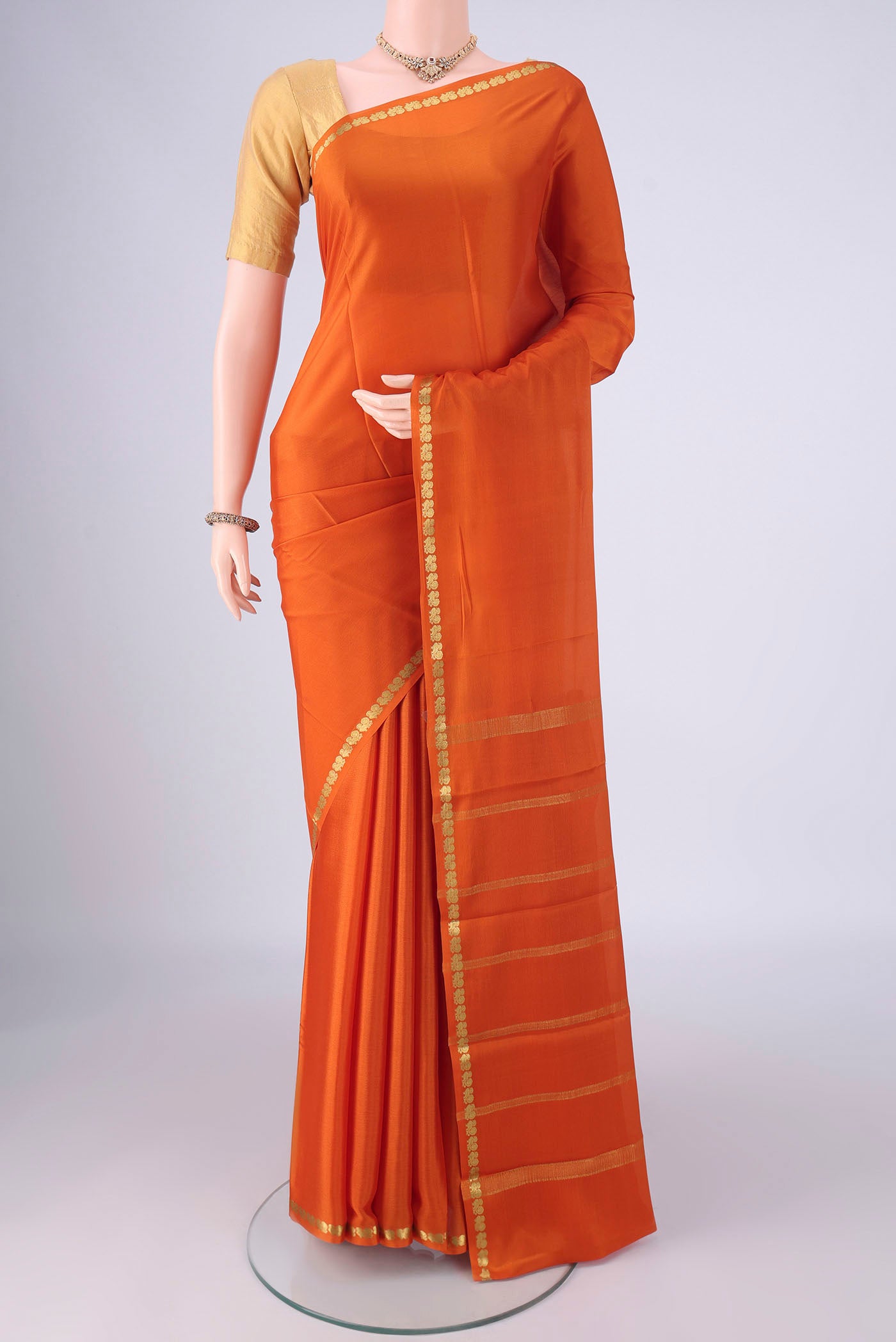 Orange Mysore Crepe Saree with Plain Body and Zari Border.  displayed on a mannequin