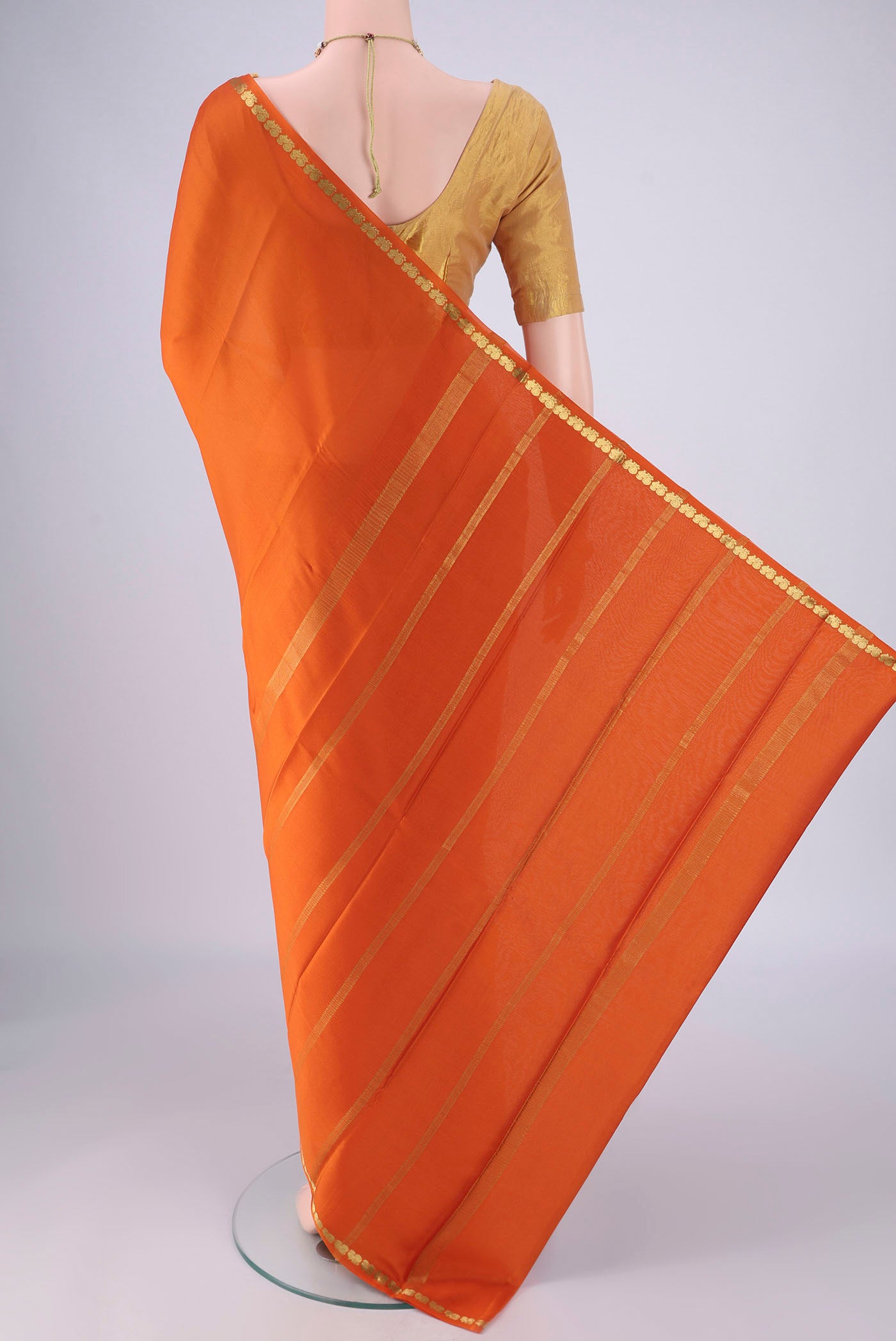 Flat view of Orange Mysore Crepe Saree with Plain Body and Zari Border. 