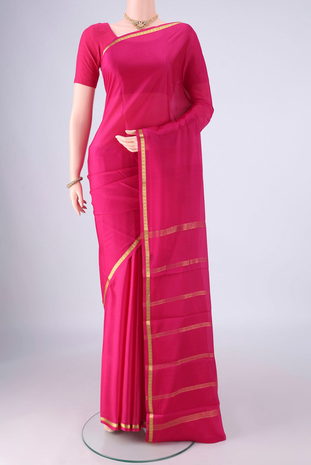 Rani Pink Mysore Crepe Saree with Plain Body and Zari Border.  displayed on a mannequin