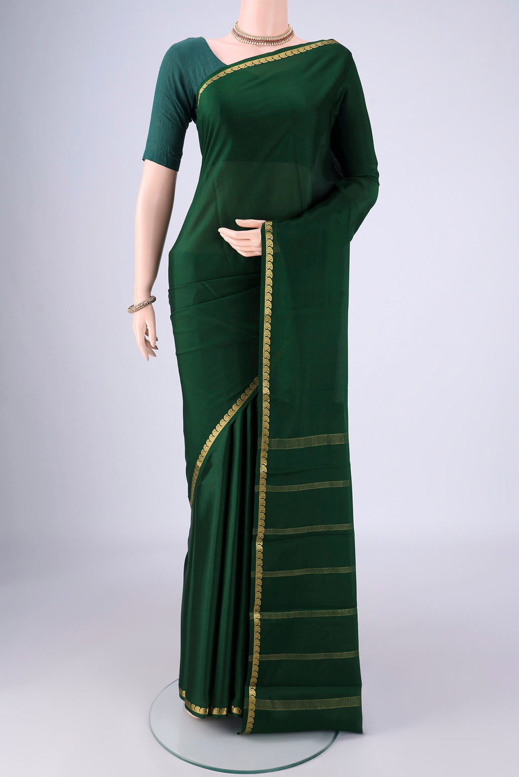 Bottle Green Mysore Crepe Saree with Plain Body and Zari Border.  displayed on a mannequin