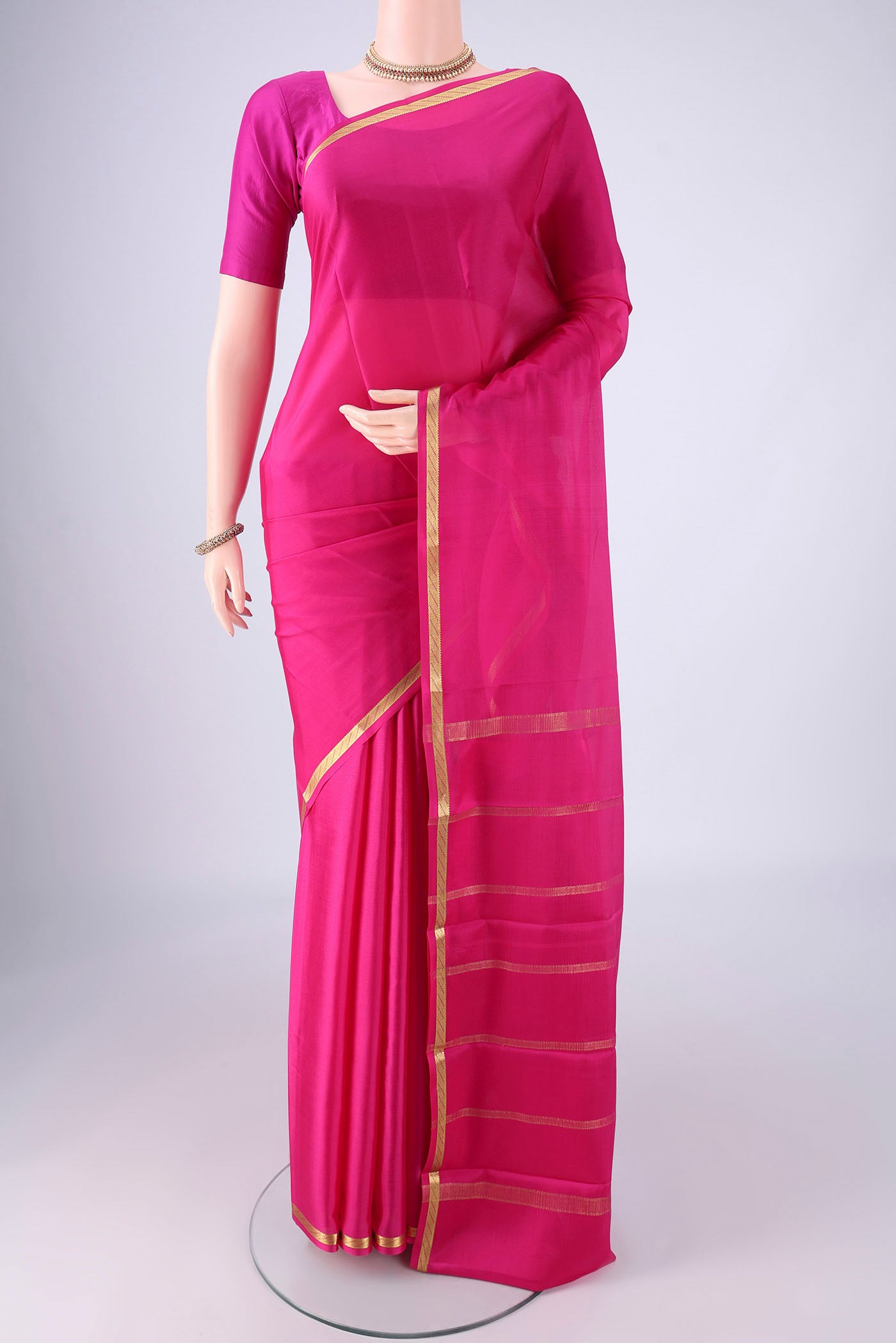 Rani Pink Mysore Crepe Saree with Plain Body and Zari Border.  displayed on a mannequin