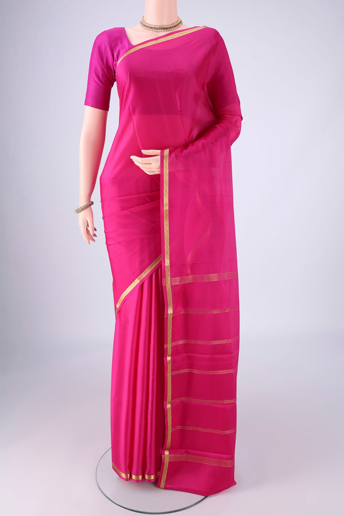 Rani Pink Mysore Crepe Saree with Plain Body and Zari Border.  displayed on a mannequin
