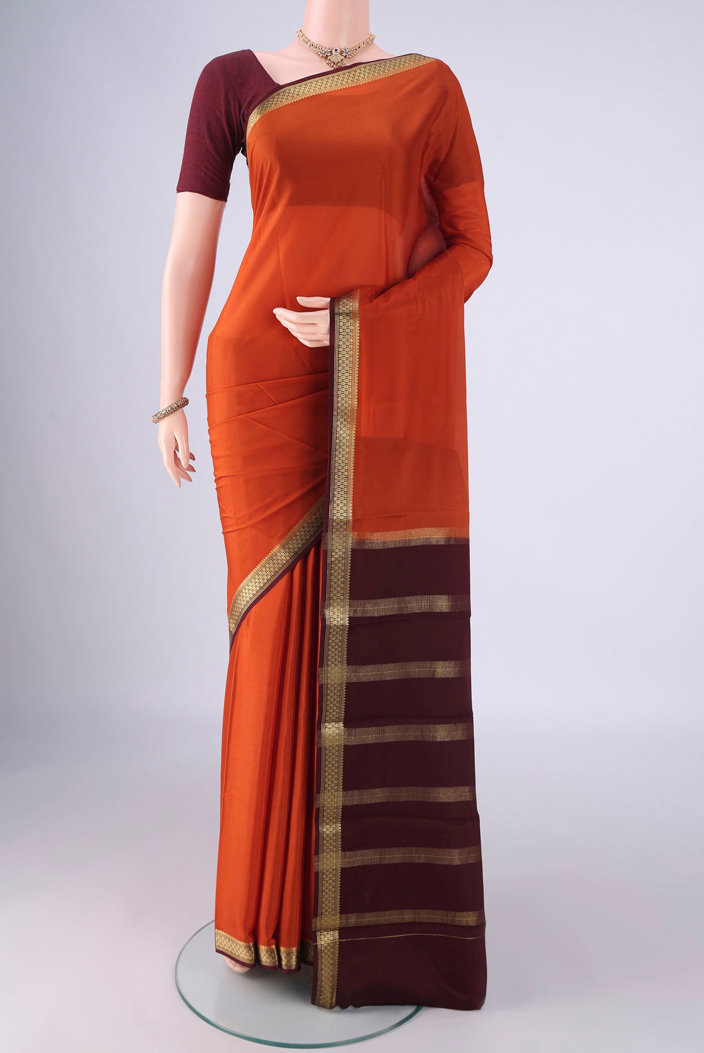 Rust Mysore Crepe Saree with Plain Body and Zari Border.  displayed on a mannequin
