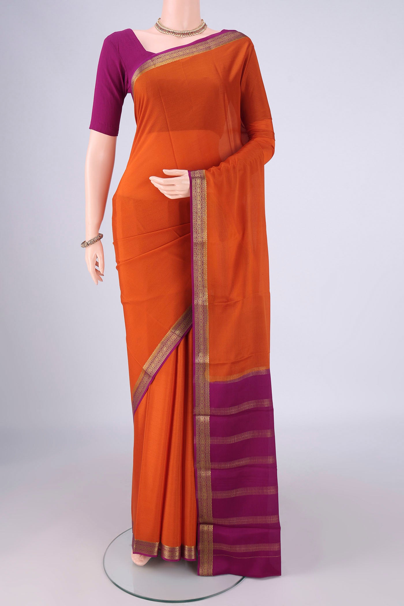 Orange Mysore Crepe Saree with Plain Body and Zari Border.  displayed on a mannequin