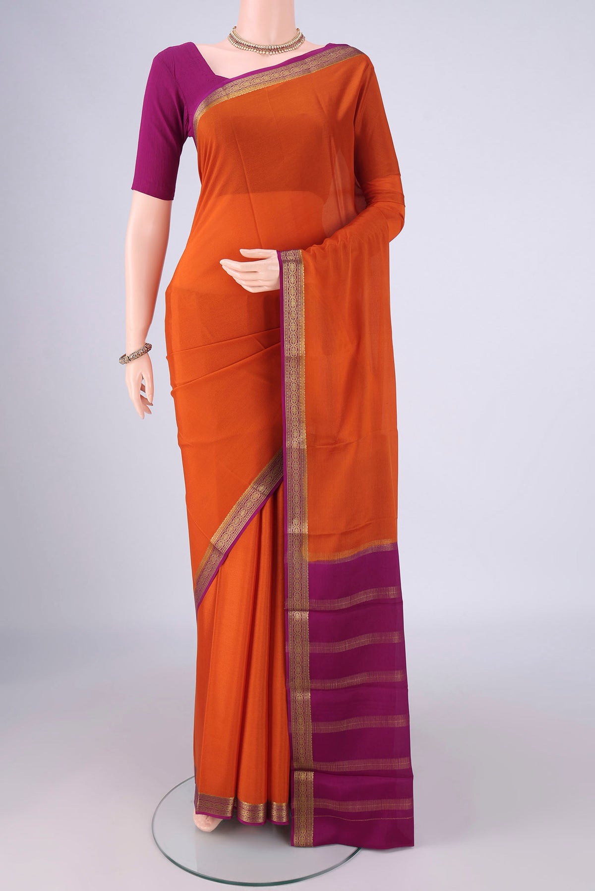 Orange Mysore Crepe Saree with Plain Body and Zari Border.  displayed on a mannequin