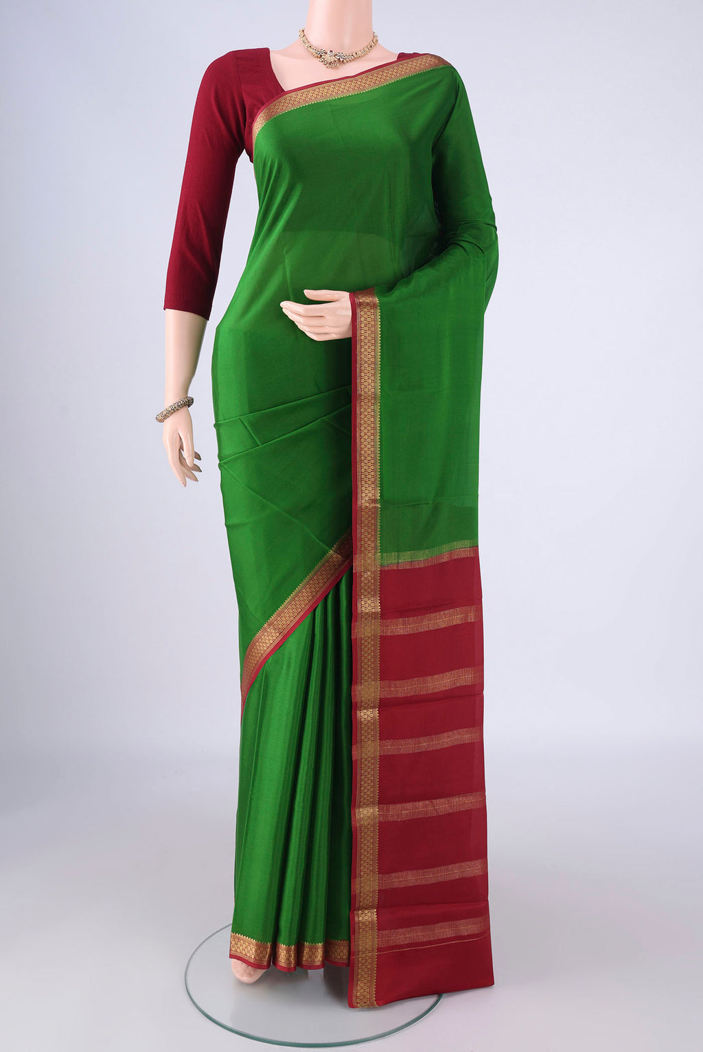 Green Mysore Crepe Saree with Plain Body and Zari Border.  displayed on a mannequin