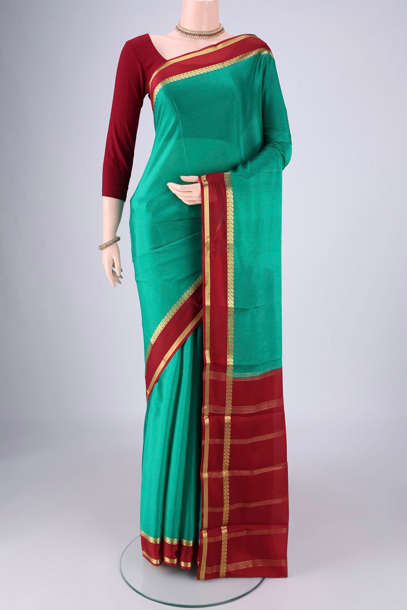 Sea Green Mysore Crepe Saree with Plain Body and Zari Border.  displayed on a mannequin