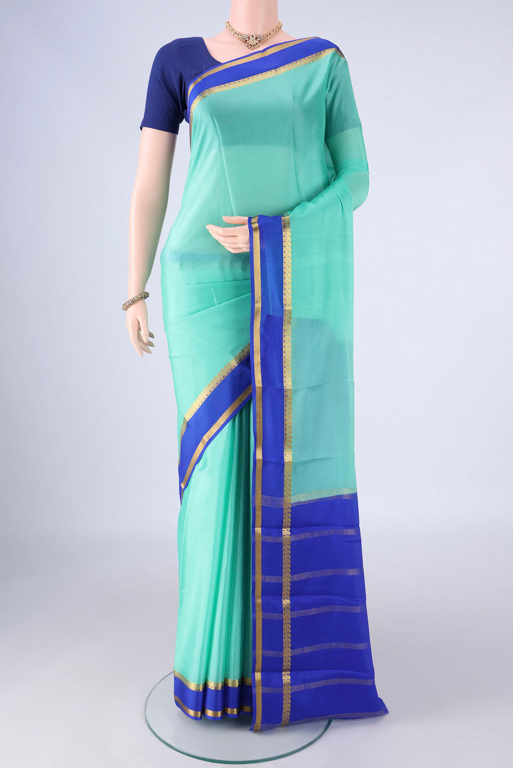 Mint Green Mysore Crepe Saree with Plain Body and Zari Border.  displayed on a mannequin