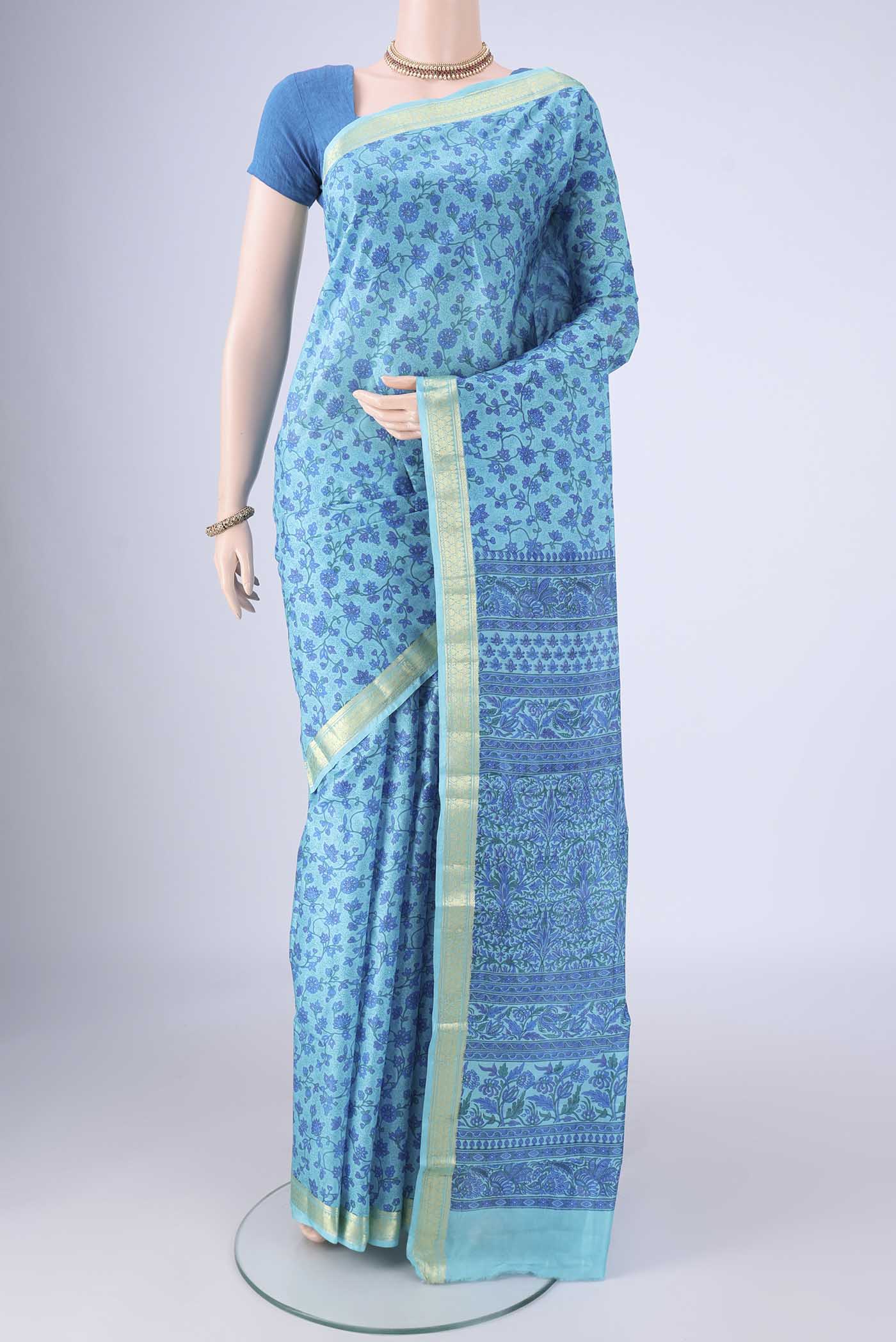 Blue Printed Silk Saree with Printed design on the body and Zari Border.  displayed on a mannequin