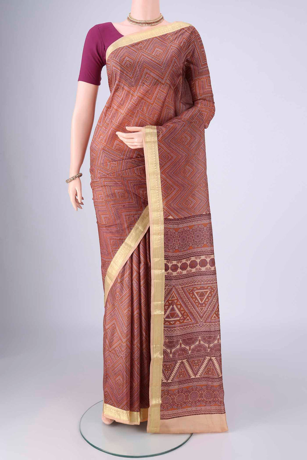 Brown Printed Silk Saree with Printed design on the body and Zari Border.  displayed on a mannequin