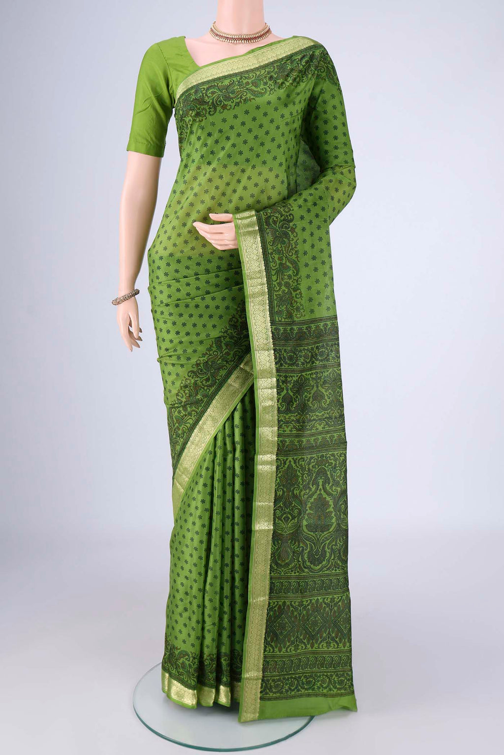 Green Printed Silk Saree with Printed design on the body and Zari Border.  displayed on a mannequin