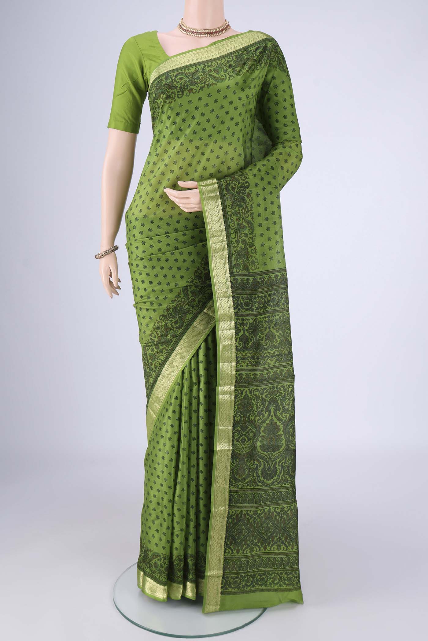 Green Printed Silk Saree with Printed design on the body and Zari Border.  displayed on a mannequin