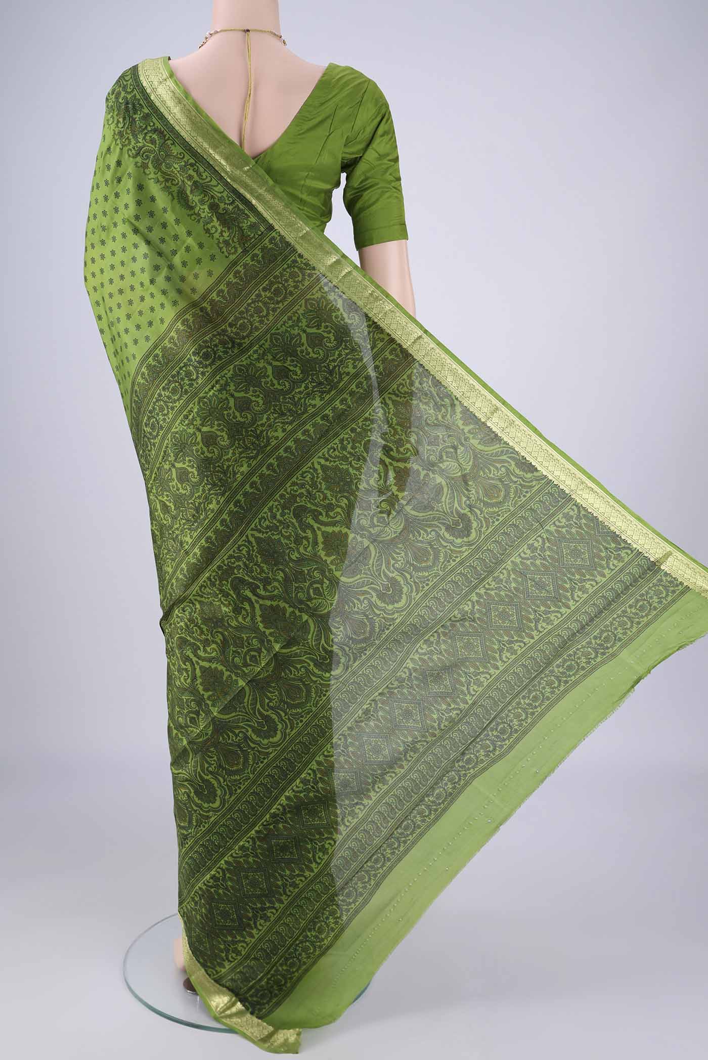 Flat view of Green Printed Silk Saree with Printed design on the body and Zari Border. 