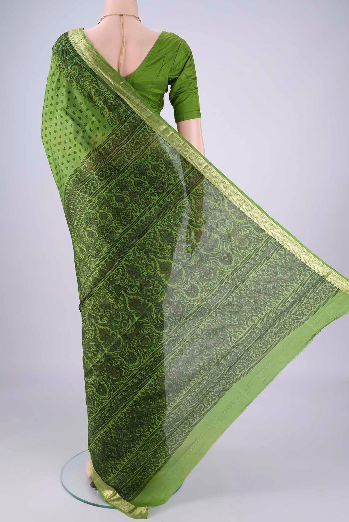 Flat view of Green Printed Silk Saree with Printed design on the body and Zari Border. 