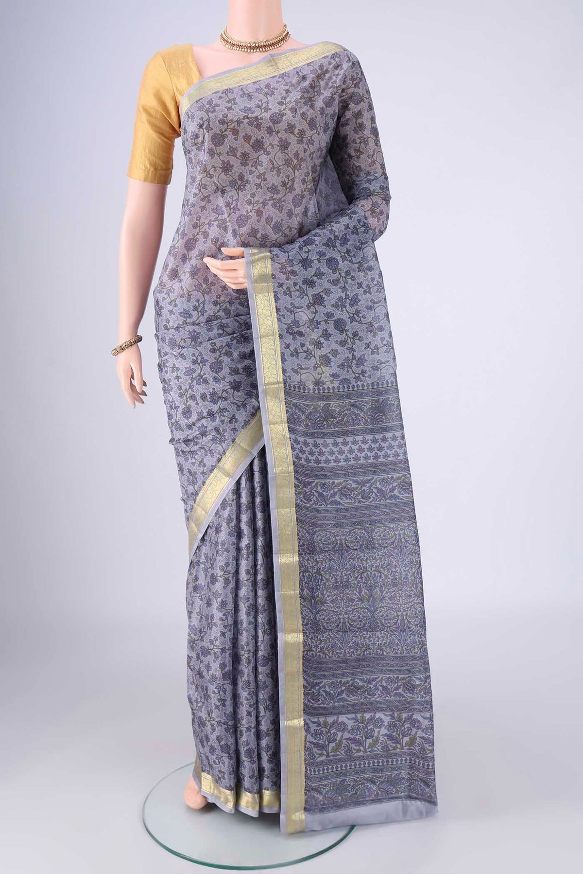 Grey Printed Silk Saree with Printed design on the body and Zari Border.  displayed on a mannequin