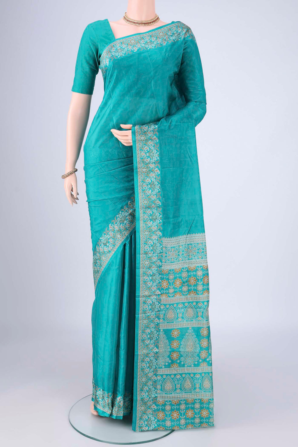Turquoise Printed Silk Saree with Plain Body and Printed Border.  displayed on a mannequin