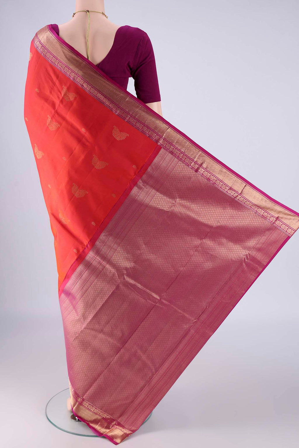 Flat view of Orange Kanchipuram Silk Saree with Zari Butta on the body and Zari Border. 