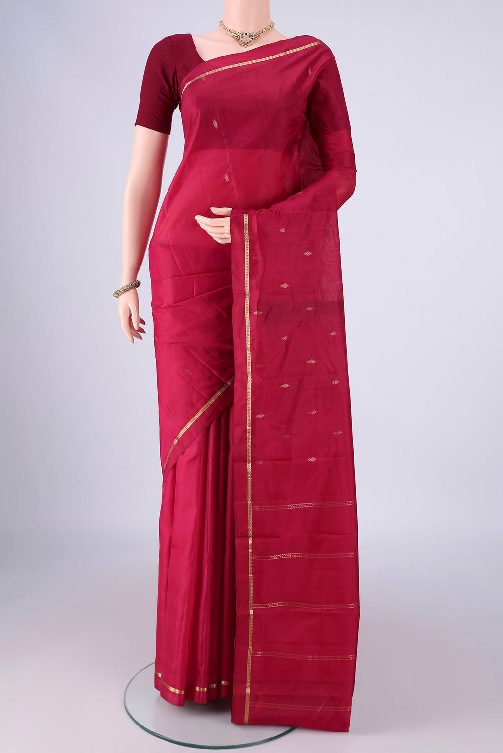 Maroon Kanjivaram Silk Saree with Zari Butta on the body and Zari Border.  displayed on a mannequin