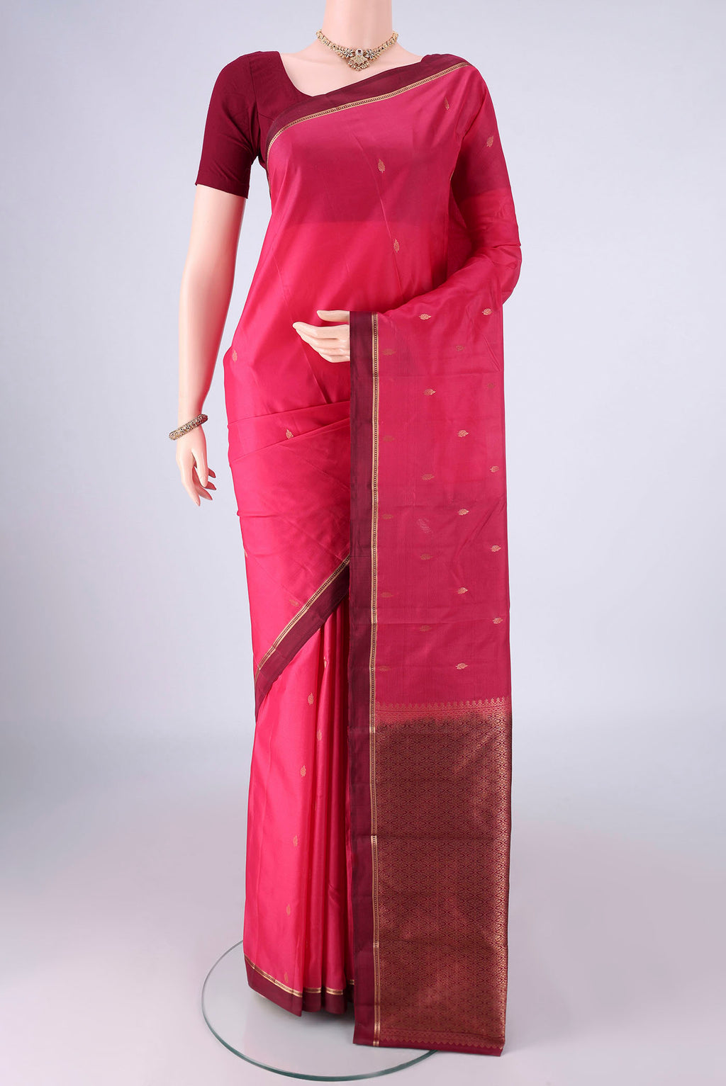 Pink Kanjivaram Silk Saree with Zari Butta on the body and Zari Border.  displayed on a mannequin