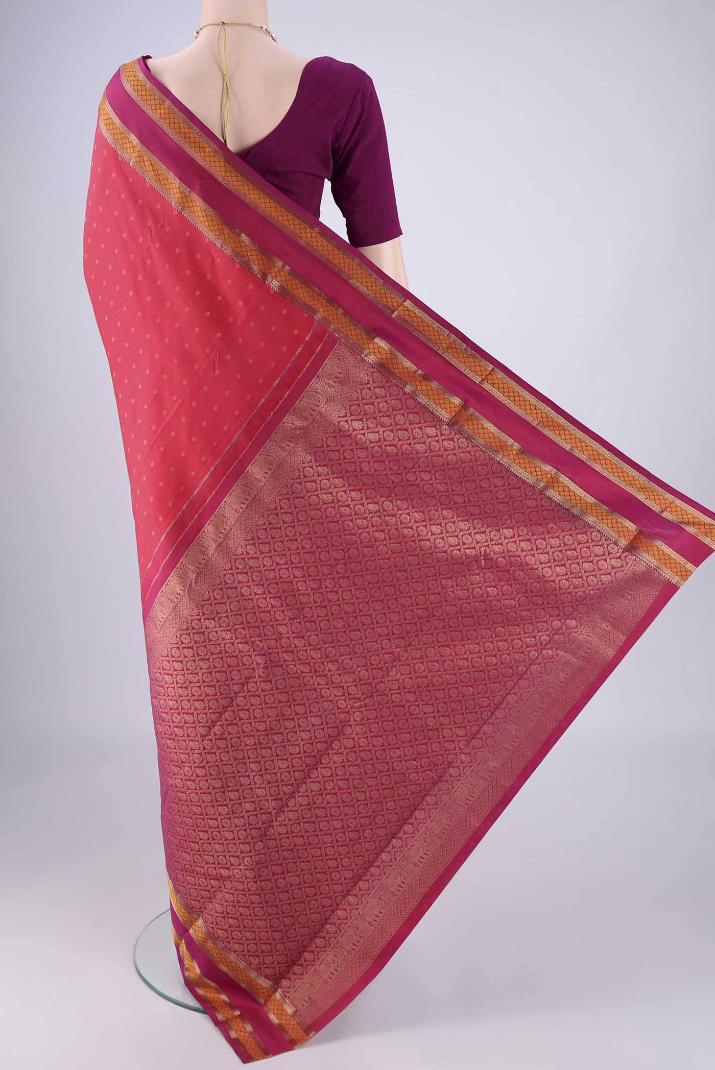 Flat view of Coral Kanchipuram Silk Saree with Zari Butta on the body and Zari And Thread Border. 